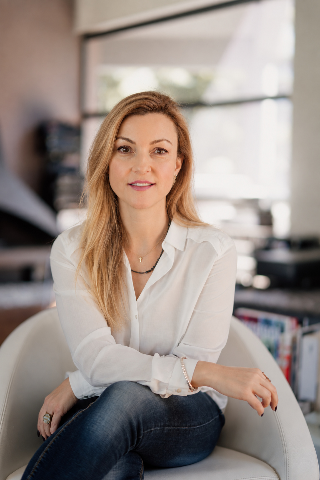 Eleni seated in a white shirt and jeans
