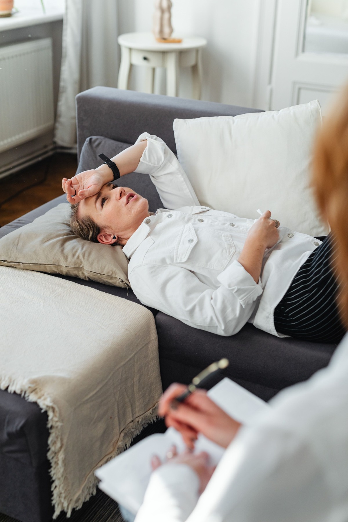 A woman reclining on a sofa in conversation